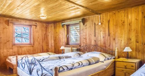two beds in a room with wooden walls at Ferienhaus Pfisterhof in Kirchzarten