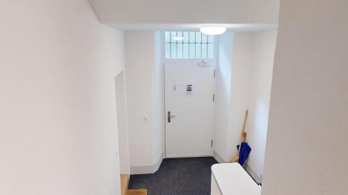 a hallway with white walls and a white door at 2 Zimmerwohnung - Zentral - 65“ TV - Arbeitsplatz in Chur