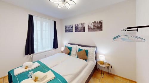 a bedroom with a white bed and a window at 2 Zimmerwohnung - Zentral - 65“ TV - Arbeitsplatz in Chur