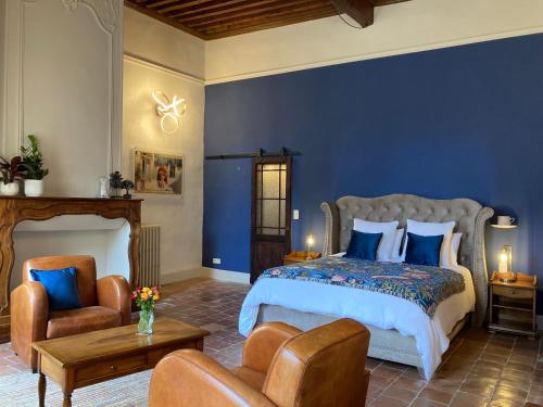 ein Schlafzimmer mit einem Bett, einem Sofa und einem Stuhl in der Unterkunft Les Ordalies in Castelnaudary