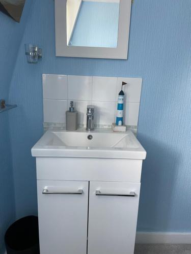a bathroom with a white sink and a mirror at Seascape guest house in Melcombe Regis