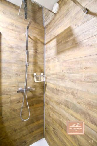 La salle de bains est pourvue d'une douche et d'un mur en bois. dans l'établissement Le Voyageur, à La Seyne-sur-Mer