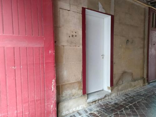 a red door on the side of a building at Logement proche Hypercentre CAEN in Caen