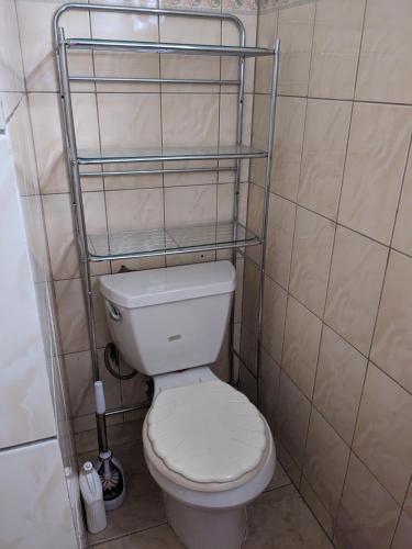 a bathroom with a toilet with a shelf above it at Bed and Breakfast in Providence