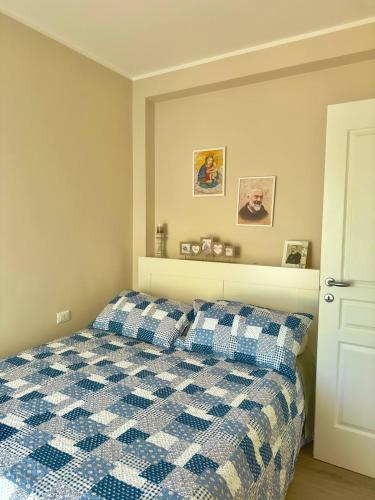 una camera con un letto a scacchi blu e bianco di Casa Luciana Apartment a San Giovanni Rotondo