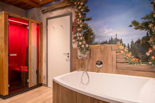 a bath tub in a bathroom with a painting on the wall at Ferienwohnung Wellvital in Bad Endorf
