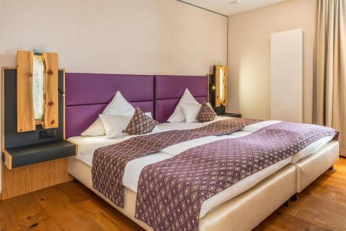 um quarto com uma cama grande e uma cabeceira de cama roxa em Ferienwohnung Wellvital em Bad Endorf