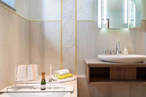 een badkamer met een wastafel en een aanrecht met een spiegel bij Ferienwohnung Atmos in Bad Endorf