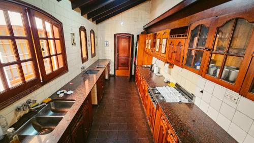 a kitchen with two sinks and wooden cabinets at Valhalla Hostel & Suites in Salta
