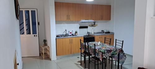 a kitchen with a table with chairs and a stove at Homestay Maio Apartment in Vila do Maio