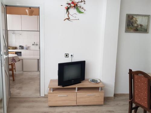 ソゾポルにあるMegi Apartmentsのリビングルーム(木製ドレッサーの上にテレビ付)
