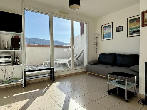 un salon avec un canapé et une grande fenêtre dans l'établissement Appartement neuf à Argelès-sur-Mer avec parking - FR-1-225-463, à Argelès-sur-Mer