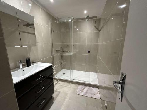 une salle de bain avec douche et lavabo dans l'établissement Appartement familial proche plage avec parking, climatisation et balcons - 6 couchages - FR-1-250-70, au Grau-du-Roi