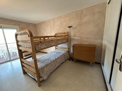- une chambre avec 2 lits superposés et une table de nuit dans l'établissement Appartement familial proche plage avec parking, climatisation et balcons - 6 couchages - FR-1-250-70, au Grau-du-Roi