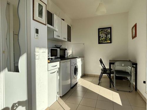 une cuisine avec une machine à laver et une table dans l'établissement Appartement neuf à Argelès-sur-Mer avec parking - FR-1-225-463, à Argelès-sur-Mer