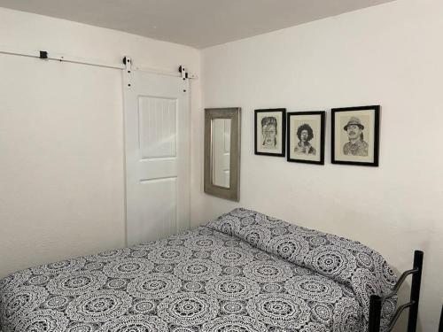 a bedroom with a bed and three pictures on the wall at Zebra Studio in Tijuana