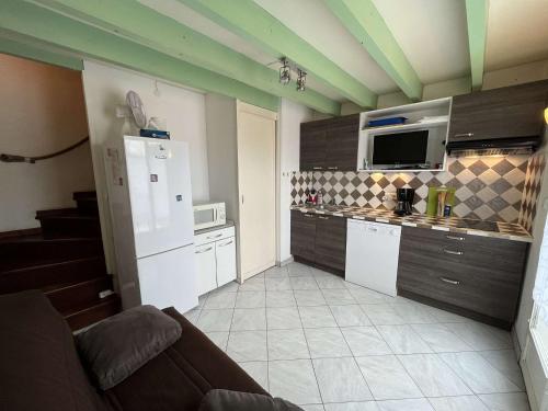 La cuisine est équipée d'un réfrigérateur blanc et d'un four micro-ondes. dans l'établissement Maisonnette 4 pers avec terrasse, piscine, proche plage, animaux acceptés - FR-1-387-145, à Marseillan