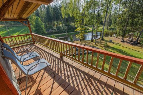 a deck with a chair and a view of a lake at Elupuu forest cabin with sauna in Nooska