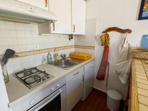 une petite cuisine avec un évier et une cuisinière dans l'établissement Charmant T2 Mezzanine, Climatisé, Piscine et Parking, Proche Plage et Loisirs, Cap d'Agde - FR-1-607-104, au Cap d'Agde