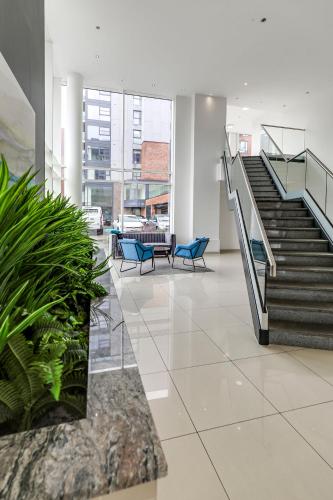 a lobby with stairs and blue chairs in a building at Stylish flat in Peterborough in Peterborough
