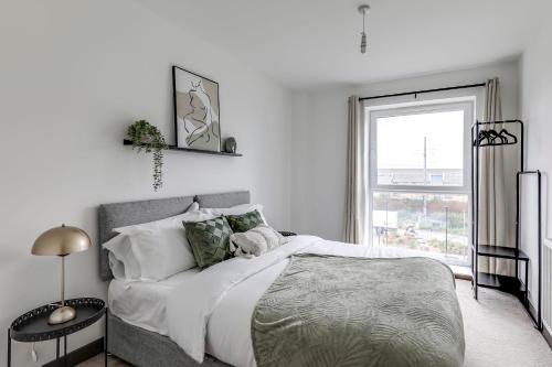 a white bedroom with a large bed and a window at Stylish flat in Peterborough in Peterborough