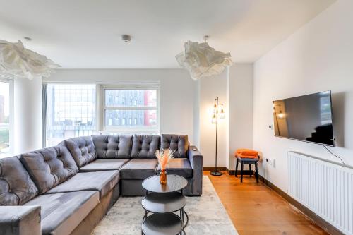 a living room with a couch and a tv at Stylish flat in Peterborough in Peterborough