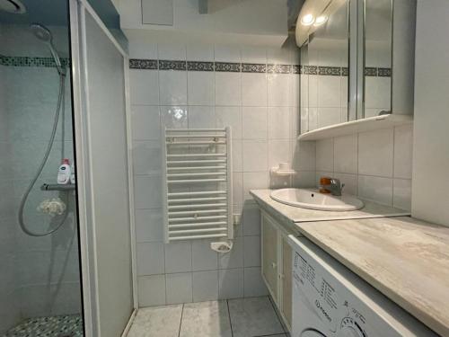une salle de bain blanche avec un lavabo et une douche dans l'établissement Villa patio proche plage avec piscine collective, cour aménagée et parking privé - FR-1-413-139, à Capbreton