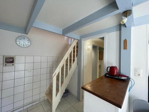 une chambre avec un escalier et une horloge sur le mur dans l'établissement Villa patio proche plage avec piscine collective, cour aménagée et parking privé - FR-1-413-139, à Capbreton