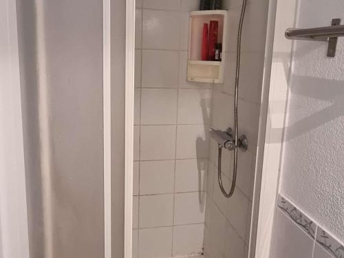 La salle de bains est pourvue d'une douche et d'une bouteille rouge. dans l'établissement Villa rénovée, climatisée, piscine, parking privé, proche mer, pour 6 pers. - FR-1-607-107, au Cap d'Agde