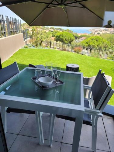 - une table en verre avec des verres sur la terrasse dans l'établissement Aux Vents du Sud, à Collioure