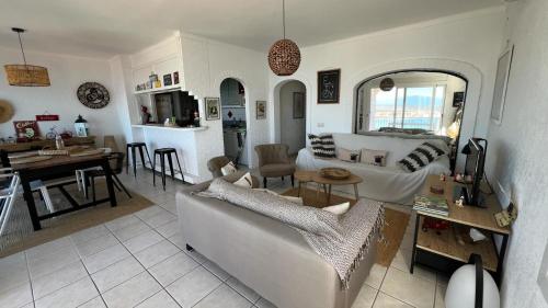 Precioso piso con vistas espectaculares del mar في روساس: غرفة معيشة مع أريكة وطاولة ومطبخ