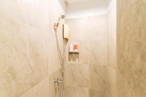 巴科洛德的住宿－RedDoorz at Nirvana Pension House，浴室内带电话的淋浴