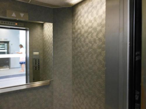a bathroom with a mirror and a person standing in the elevator at Grant Plaza Hotel in San Francisco