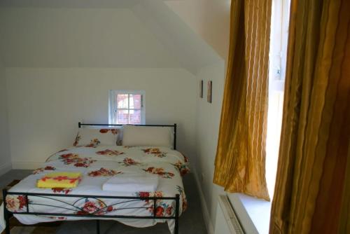 a bedroom with a bed in a room with a window at Luxury and serviced 3 bed house - Hampstead Garden in London