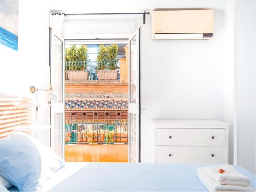 a bedroom with a door open to a balcony at Riverside Apartment in Triana in Seville