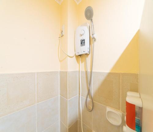 a shower in a bathroom with a blow dryer at RedDoorz at Nirvana Pension House in Bacolod