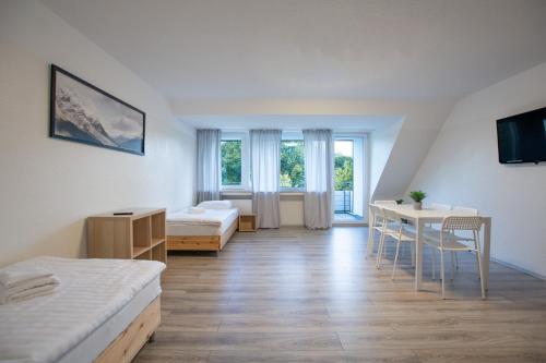 Habitación con 2 camas, mesa y sillas en T&K Apartments - 3 Room Apartment with Balcony, en Essen