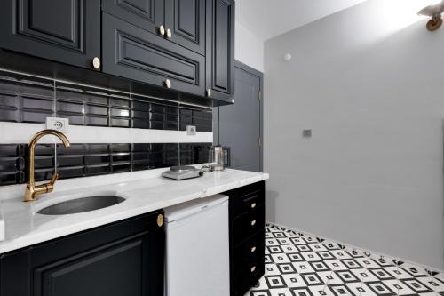 a kitchen with black cabinets and a sink at Portist Hotel in Istanbul