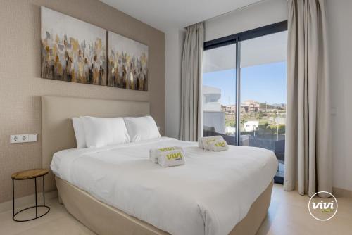 een slaapkamer met een groot wit bed en een groot raam bij Deco in Fuengirola