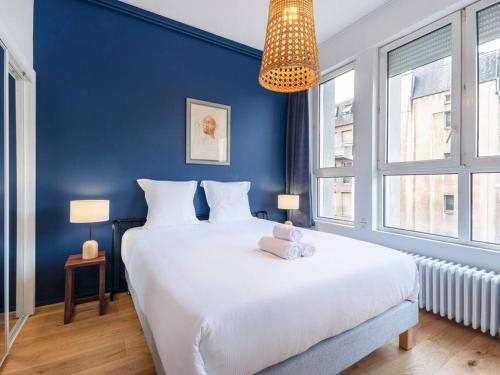 - une chambre avec un grand lit blanc et un mur bleu dans l'établissement L'Excellent de Dumas, à Nancy