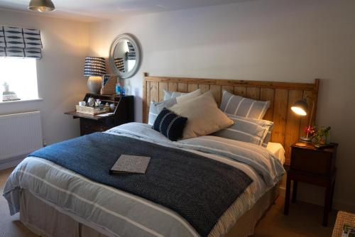 a bedroom with a large bed with a wooden headboard at The Saxon Inn in Blandford Forum