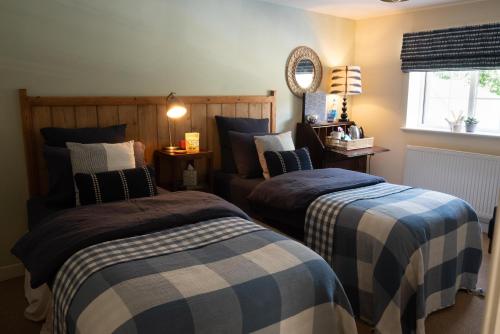 a bedroom with two beds and a window at The Saxon Inn in Blandford Forum