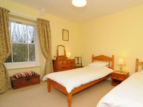 a bedroom with two beds and a window at Frondeg Nanternis in Llanllwchaiarn