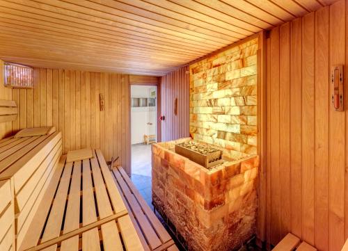 a sauna with a stone wall and wooden walls at Residenz am Balmer See - BS 53 mit Wellnessbereich in Balm