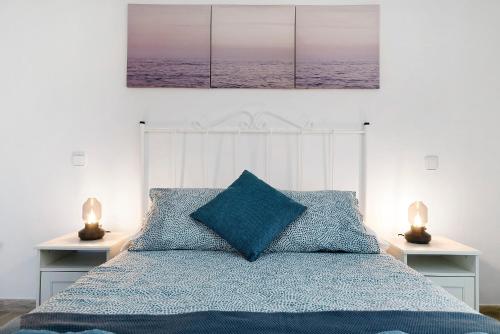 a bedroom with a blue bed with two lamps on tables at Viviendas El Pescador - Vela in El Golfo