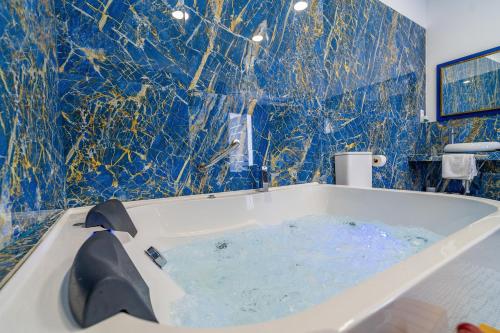 a bathroom with a tub with blue tiles at CASA DE LA SEÑORA in Palma del Río