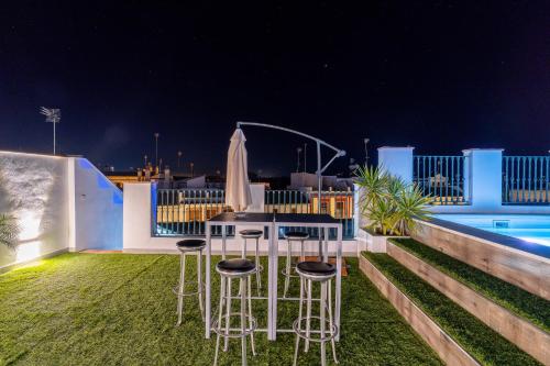 a patio with chairs and a table and a pool at CASA DE LA SEÑORA in Palma del Río