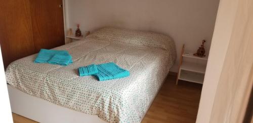a bed with two blue towels on top of it at Exelente Departamento in La Plata