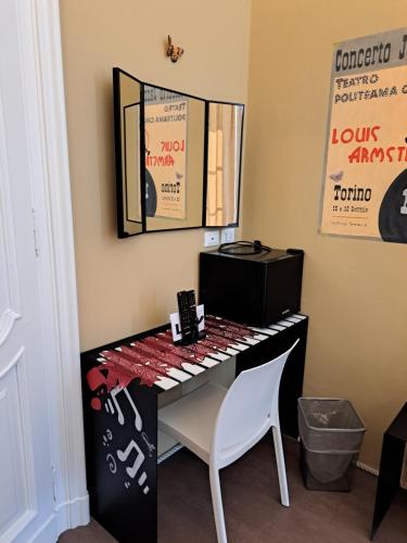 pianoforte bianco e nero in una stanza con specchio di Loca a Torino