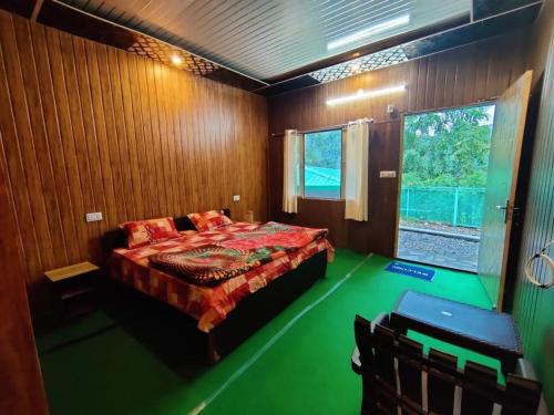 um quarto com uma cama e um piso verde em Narayan valley resrot & hotel Sonparyag em Trijugi Nārāyan
